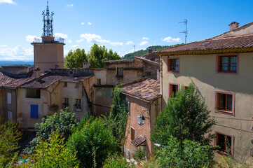 Travel destination, small ancient village Cotignac in Provence, surrounded by vineyards and cliffs with troglodytes houses.