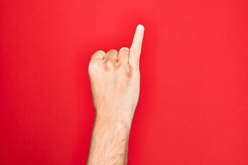 Hand of caucasian young man showing fingers over isolated red background showing little finger as...
