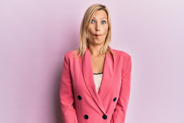 Middle age caucasian woman wearing business jacket making fish face with lips, crazy and comical gesture. funny expression.