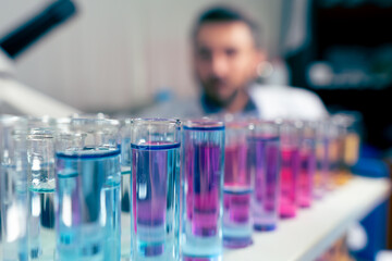 Chemist working behind test tubes