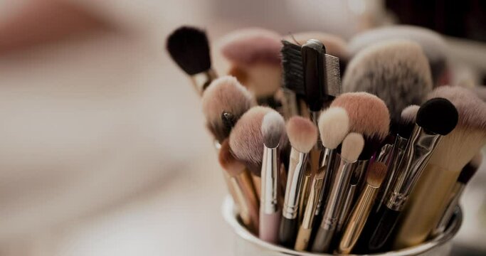 Close up of several makeup brushes in box on table
