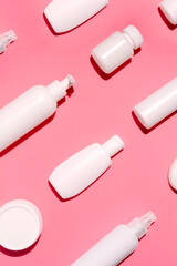 Mock up pattern for branding on pink background. Tubes, bottles, dispensers and jars. Dietary supplements for beauty and health. Flat lay, top view