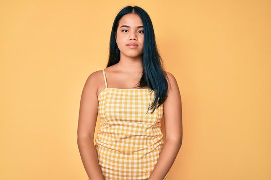 Young beautiful asian girl wearing casual clothes with serious expression on face. simple and natural looking at the camera.
