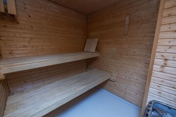 View of sauna room interior. Wooden walls and seats. Health concept.