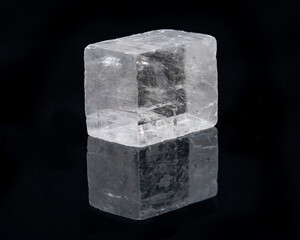 Optical Calcite from China isolated on a black mirror background. Alternative stone name: Iceland Spar.