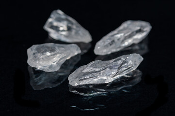 Clear Satyaloka Quartz from Southern India isolated on a black mirror background.