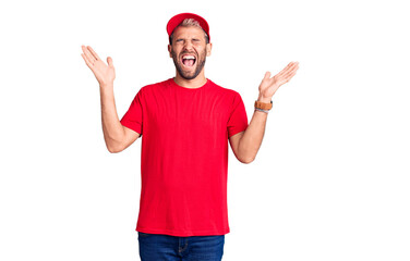 Young handsome blond man wearing t-shirt and cap celebrating mad and crazy for success with arms...