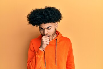 Fototapeta na wymiar Young african american man with afro hair wearing casual sweatshirt feeling unwell and coughing as symptom for cold or bronchitis. health care concept.