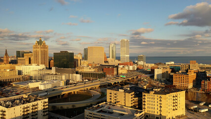 Aerial view of American city at sunset. Modern buildings, skyscrapers. Cloudy sky, cityscape....