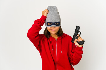 Young robber hispanic woman wearing a mask being shocked, she has remembered important meeting.