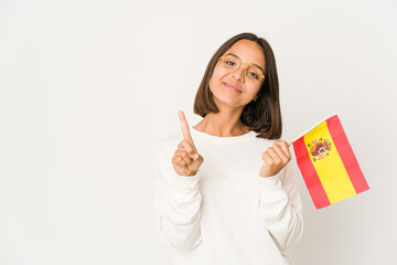 Young hispanic mixed race woman holding a spanish flag showing number one with finger.