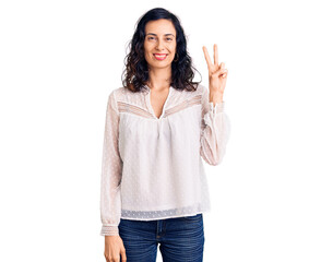 Young beautiful hispanic woman wearing casual clothes smiling with happy face winking at the camera doing victory sign. number two.