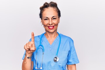 Middle age brunette nurse woman wearing uniform and stethoscope over white background smiling with...