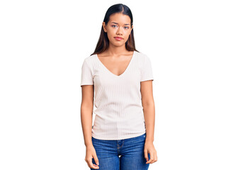 Fototapeta premium Young beautiful latin girl wearing casual white t shirt with serious expression on face. simple and natural looking at the camera.