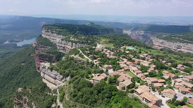 Picturesque green summer landscape with ancient stone buildings of Tavertet town on top of cliff, Collsacabra, Catalonia, Spain. High quality 4k footage