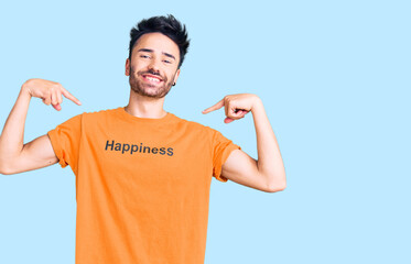 Young hispanic man wearing t shirt with happiness word message looking confident with smile on...