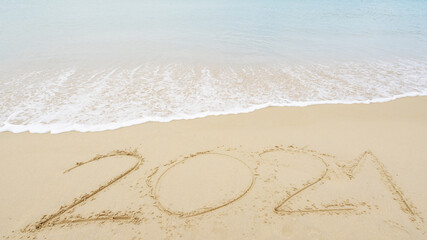 Happy New Year 2021 lettering Text on the beach with wave and white sea foam Numbers 2021 year on the seashore wave crashing on sandy shore Concept happy new year and nature new idea design background