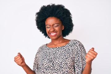 Young african american woman wearing casual clothes very happy and excited doing winner gesture with arms raised, smiling and screaming for success. celebration concept.