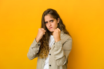 Young caucasian woman showing fist to camera, aggressive facial expression.