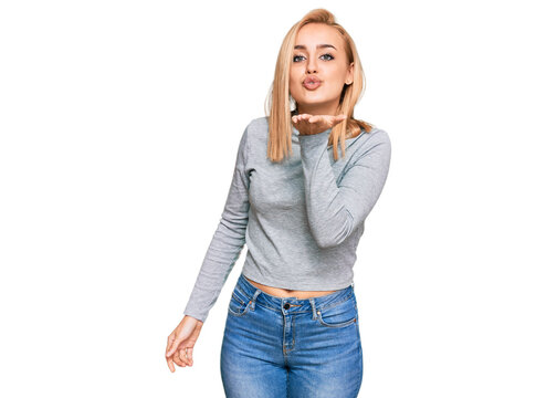 Beautiful caucasian woman wearing casual clothes looking at the camera blowing a kiss with hand on air being lovely and sexy. love expression.