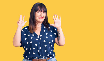 Young plus size woman wearing casual clothes showing and pointing up with fingers number nine while smiling confident and happy.