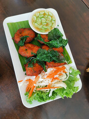Fish cake, fried spicy fish balls top with crispy basil and sweet sauce.