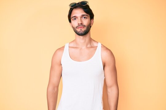 Handsome hispanic man wearing summer look and sunglasses relaxed with serious expression on face. simple and natural looking at the camera.