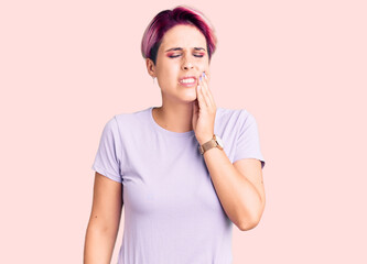 Young beautiful woman with pink hair wearing casual clothes touching mouth with hand with painful expression because of toothache or dental illness on teeth. dentist