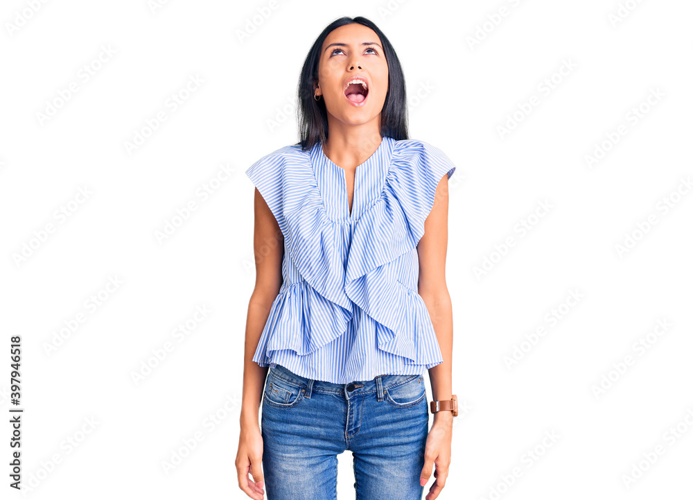 Poster young beautiful latin girl wearing casual clothes angry and mad screaming frustrated and furious, sh