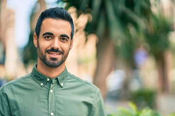 Fototapeta premium Young hispanic man smiling happy standing at the city.