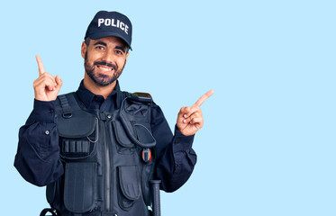 Young hispanic man wearing police uniform smiling confident pointing with fingers to different directions. copy space for advertisement