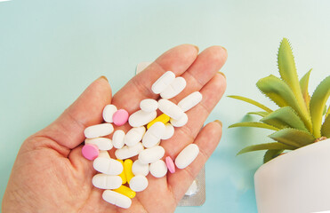 A handful of medical pills in the palm of your hand for the treatment of diseases, a WOMAN's HAND...
