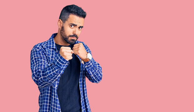 Young hispanic man wearing casual clothes ready to fight with fist defense gesture, angry and upset face, afraid of problem