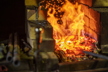The metal spiral is heated to red in the forge in the forge during forging