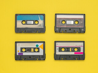 Four tape recorders on a yellow background.