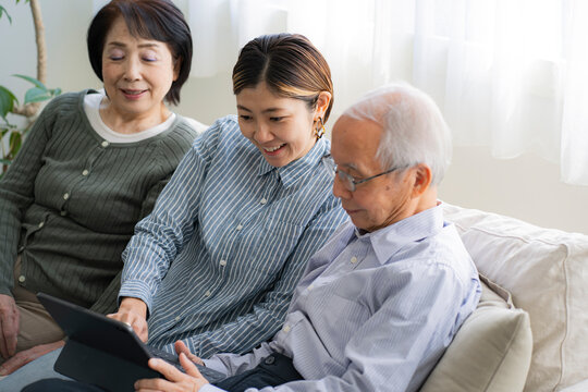 タブレットPCを見る日本人親子・二世代家族