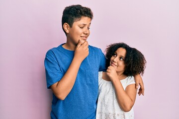 Young hispanic family of brother and sister wearing casual clothes together with hand on chin thinking about question, pensive expression. smiling and thoughtful face. doubt concept.