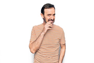 Middle age handsome man wearing striped t-shirt standing over isolated white background smiling looking confident at the camera with crossed arms and hand on chin. Thinking positive.