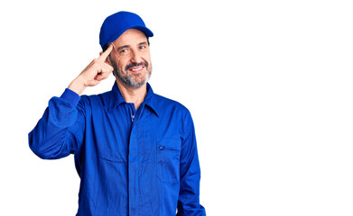 Middle age handsome man wearing mechanic uniform smiling pointing to head with one finger, great idea or thought, good memory