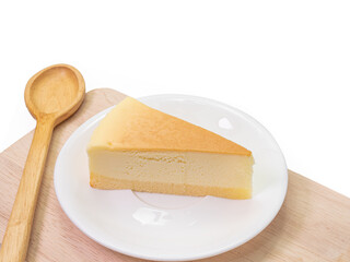 The close up of sliced yummy cheesecake bakery sweet dessert and wooden spoon on wood cutting board isolated on white background.