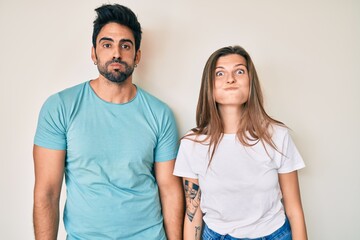 Beautiful young couple of boyfriend and girlfriend together puffing cheeks with funny face. mouth...