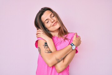 Beautiful caucasian woman wearing casual clothes hugging oneself happy and positive, smiling confident. self love and self care