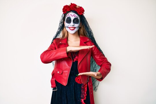 Woman wearing day of the dead costume over white gesturing with hands showing big and large size sign, measure symbol. smiling looking at the camera. measuring concept.