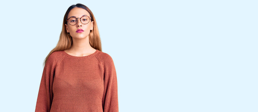 Beautiful young woman wearing casual clothes and glasses relaxed with serious expression on face. simple and natural looking at the camera.