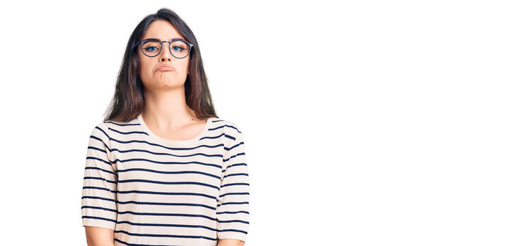 Brunette teenager girl wearing casual clothes and glasses depressed and worry for distress, crying angry and afraid. sad expression.