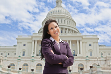 Beautiful mid adult Asian American woman in front of the U.S. Capitol building in Washington, DC - obrazy, fototapety, plakaty
