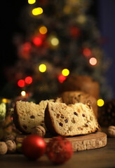 Delicious slice of Panettone with candied fruit on the table on a blurred background