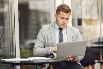 Businessman. Guy in a suit. Malw use a laptop.