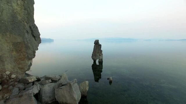 Drone view of the rocky arch in sea and rocky coast a cloudy day.