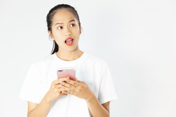 Image of excited young asia woman using and pointing finger at cellphone isolated over white background
